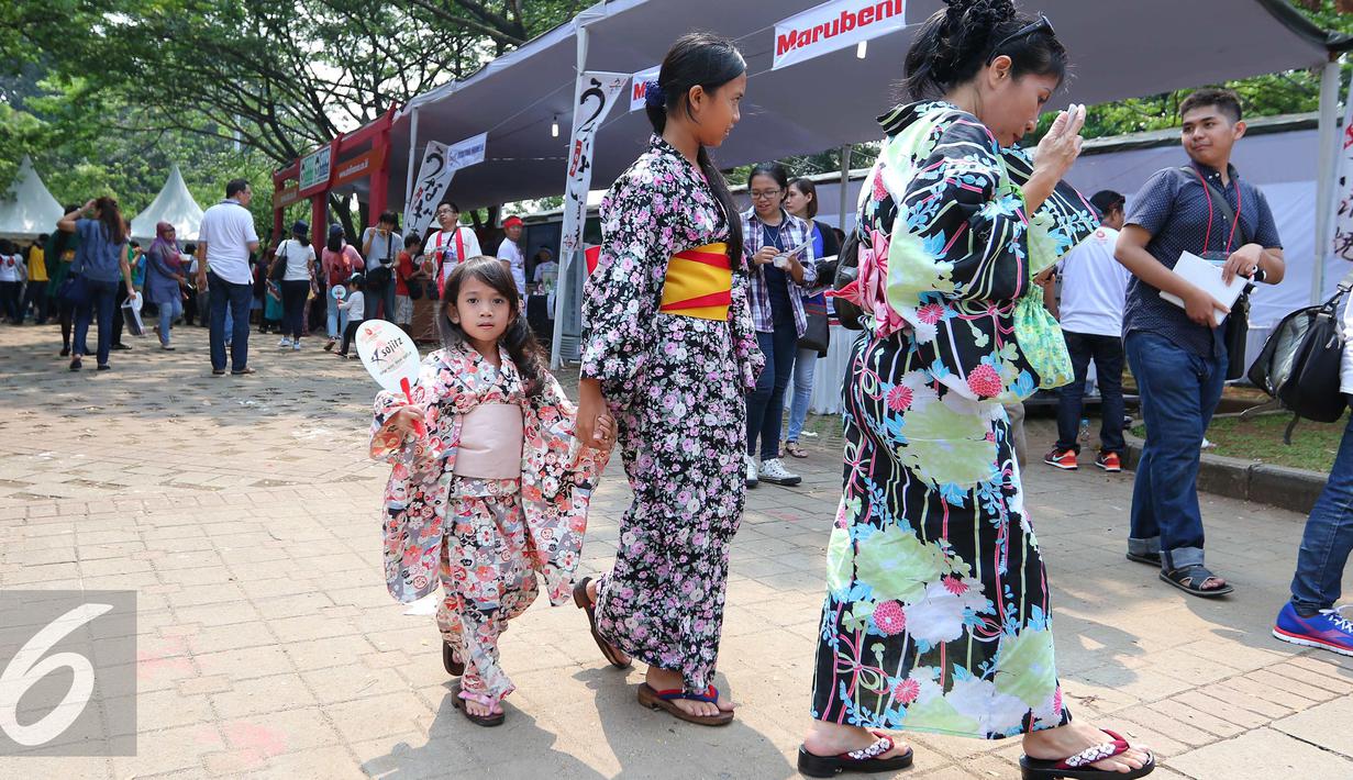 Pengunjung berjalan menggunakan kimono saat festival Jak-Japan Matsuri 2016 di Senayan, Jakarta, Sabtu (3/9). Festival tersebut sekaligus untuk memperingati 60 tahun hubungan diplomatik Indonesia-Jepang. (Liputan6.com/Angga Yuniar)