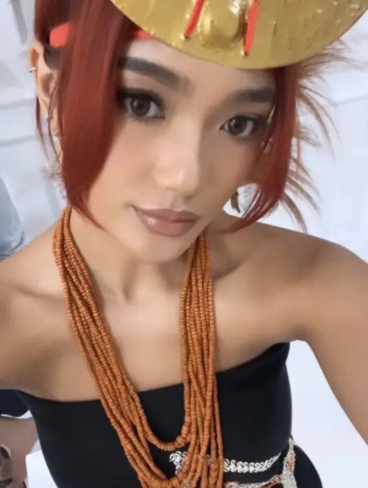 Untuk makeup, ia tampil glam natural dengan mengaplikasikan lipstik nude glossy dan blush on pink menonjolkan tulang pipi. Serta eyeshadow nude dan eyeliner wings pada riasan mata [@lalamarionmj]