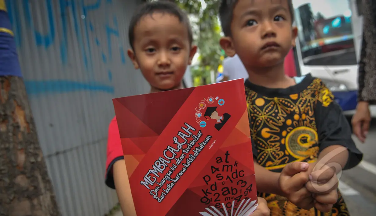Seorang anak menunjukan buku yang dibagikan Presiden Joko Widodo seusai acara makan siang bersama kepala negara serta delegasi negara-negara peserta Konferensi Asia Afrika di Jalan Cicendo, Bandung, Jumat (24/4/2015). (Liputan6.com/Faizal Fanani)