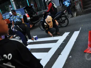 Relawan tergabung dari Koalisi Pejalan Kaki membuat jalur zebra cross di depan Stasiun Sudirman, Jakarta, Jumat (13/3/2015). (Liputan6.com/Faizal Fanani)