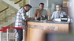 Tersangka Irvanto Hendra Pambudi menulis buku tamu di gedung KPK, Jakarta, Jumat (9/3). Keponakan Setya Novanto menjalani pemeriksaaan kasus korupsi proyek pengadaan paket penerapan Kartu Tanda Penduduk (KTP) elektronik. (Liputan6.com/Herman Zakharia)