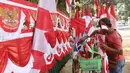 Penjual bendera musiman merapikan dagangannya di pinggir trotoar kawasan Pasar Minggu, Jakarta, Kamis (2/8). Menjelang perayaan HUT RI ke-73, sejumlah penjual bendera dan umbul-umbul mulai bermunculan di berbagai sudut Kota. (Liputan6.com/Herman Zakharia)
