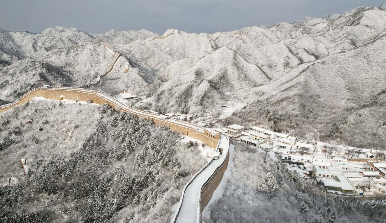 Hamparan pegunungan yang ada disekitarnya pun memutih tertutup oleh salju. (GREG BAKER/AFP)