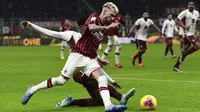 Striker AC Milan, Samu Castillejo, berusaha melewati bek Torino, Ola Aina, pada laga Coppa Italia di Stadion San Siro, Milan, Selasa (28/1). Milan menang 4-2 atas Torino. (AFP/Miguel Medina)