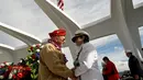 Veteran yang selamat dari bom Pearl Harbor, Paul Hilliard bersalaman dengan Admiral Chaplain, Margaret Kibben di atas kapal USS Arizona memorial saat upacara peringatan 75 tahun pengeboman Pearl Harbor di Honolulu, Hawaii (7/12). (Reuters/Hugh Gentry)