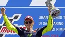 Pembalap Yamaha MotoGP, Valentino Rossi, mengangkat trofi kemenangan usai menjadi kampiun di Grand Prix San Marino, Italia, (14/9/2014). (REUTERS/Max Rossi)