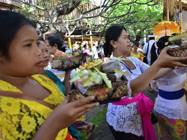 Sejumlah umat Hindu Bali membawakan sesajen untuk sembahyang Hari Raya Galungan di Pura Jagat Natha di Denpasar, Bali (1/11). Galungan dimaknai sebagai hari kemenangan Dharma (Kebaikan) melawan Adharma (Keburukan). (AFP Photo/Sonny Tumbelaka)