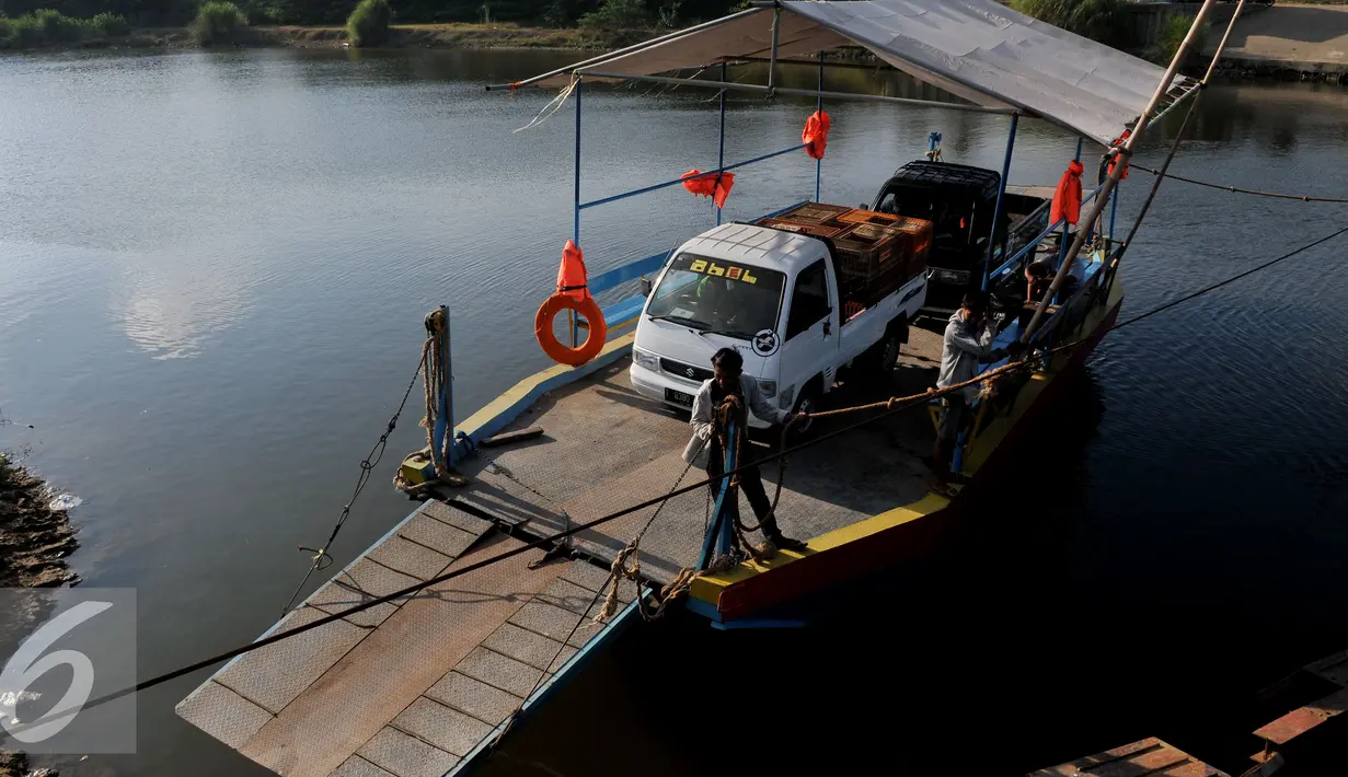 Pekerja menarik perahu eretan berisi kendaraan menyebrangi Sungai Citarum di Muara Gembong, Bekasi, Rabu, (29/7/2015). Kendaraan yang menyebrang menggunakan perahu eretan dikenakan biaya Rp.20.000 bagi mobil dan Rp 2.000 motor. (Liputan6.com/Johan Tallo)