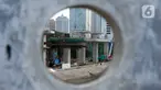 Para pekerja sedang menyelesaikan bentangan beton panjang light rail transit (LRT) di tikungan Jembatan 66 Kuningan-Dukuh Atas, Jakarta, Senin (6/7/2020). (merdeka.com/Dwi Narwoko)