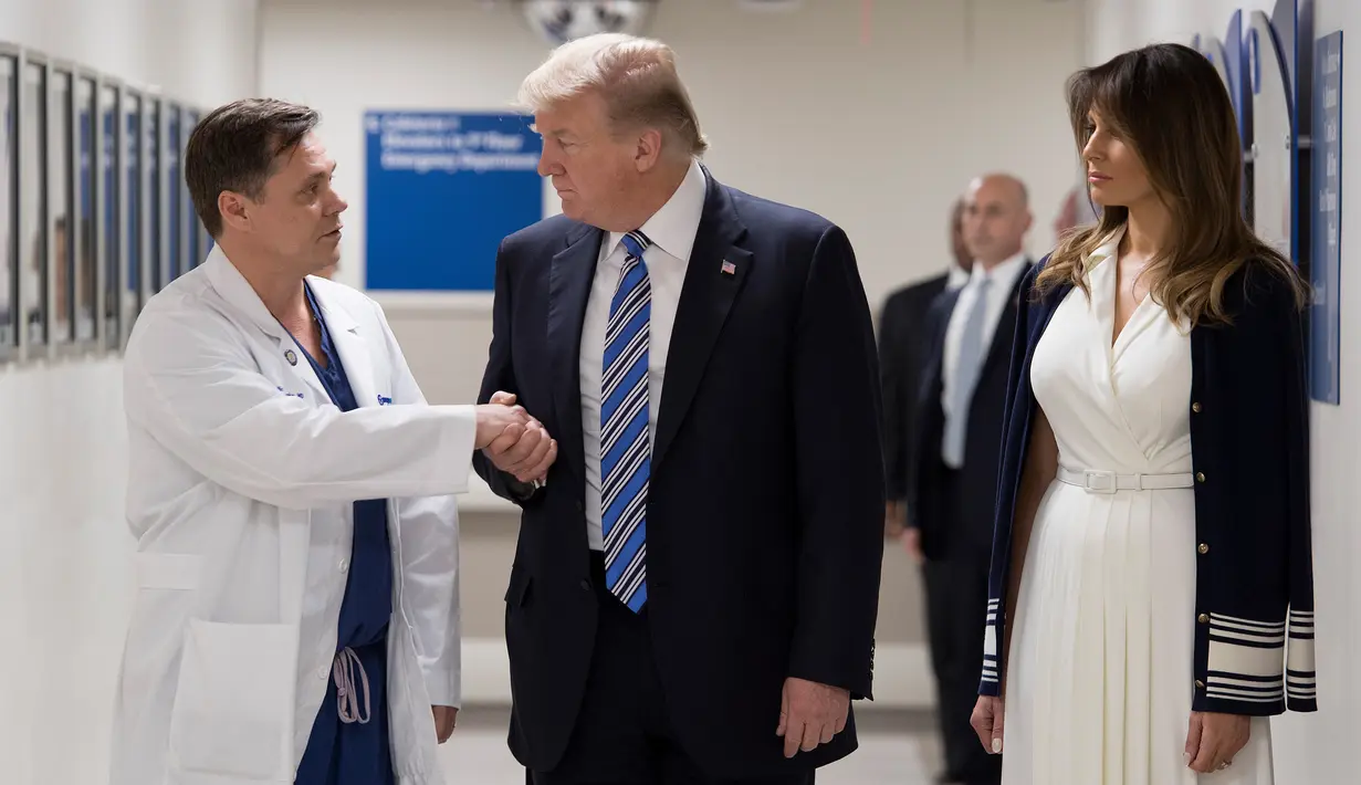 Presiden AS Donald Trump (tengah) berjabat tangan dengan dokter Igor Nichiporenko (kiri) saat mengunjungi rumah sakit Broward Health North Pompano Beach, Florida (16/2). (AFP Photo/Jim Watson)