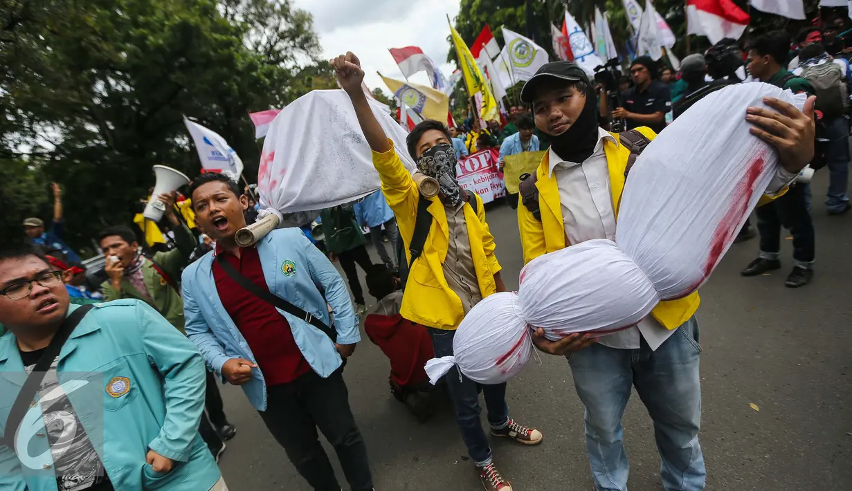 Peserta aksi membawa keranda jenazah saat menggelar aksi unjuk rasa di depan Istana Negara, Kamis (12/1). Mereka adalah mahasiswa yang tergabung dalam Badan Eksekutif Mahasiswa (BEM) se-Jabodetabek. (Liputan6.com/Faizal Fanani)