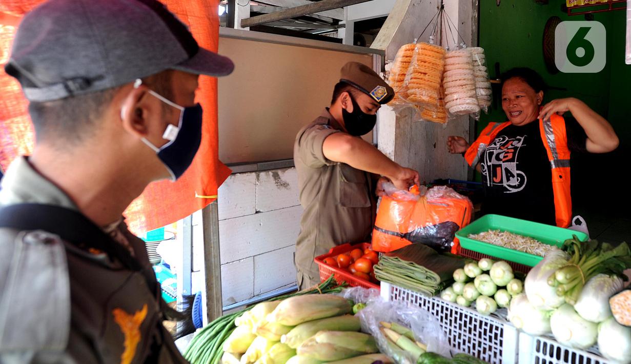 Pelanggar PSBB mengenakan rompi khusus saat razia masker di Pasar Reni, Pamulang, Tangerang Selatan, Banten, Selasa (1/9/2020). Razia terhadap pedagang dan pengunjung pasar ini juga dilakukan rapid test guna mencegah penularan COVID-19. (merdeka.com/Arie Basuki)