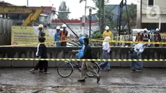 Warga melintasi lokasi semburan gas PGN di proyek Tol Dalam Kota rute Pulogebang-Kelapa Gading, Cakung, Jakarta, Kamis (12/3/2020). Semburan gas yang terjadi sekitar pukul 10.00 WIB tersebut akibat proyek penggalian mengenai pipa distribusi PGN. (merdeka.com/Iqbal Nugroho)