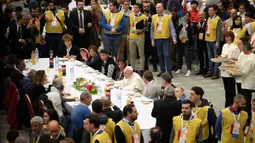 Paus Fransiskus berbincang saat menggelar jamuan makan siang di Aula Paul VI, Vatikan, Minggu (17/11/2019). Paus Fransiskus mengundang sekitar 1.500 orang miskin, tunawisma, imigran dan pengangguran untuk makan siang dalam memperingati Hari Orang Miskin Sedunia. (AP/Alessandra Tarantino)