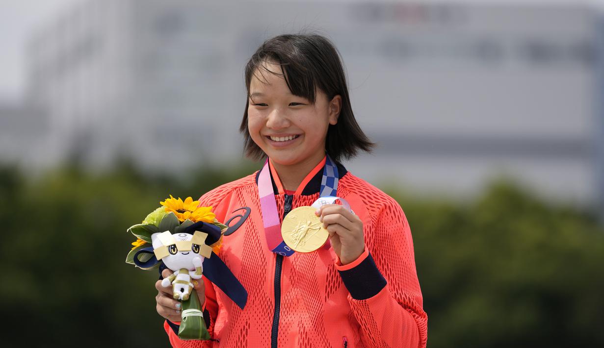 Skater Jepang Momiji Nishiya memegang medali emas setelah memenangkan final street skateboarding putri Olimpiade Tokyo 2020 di Tokyo, Jepang, 26 Juli 2021. Saat ini, Momiji tercatat sebagai atlet termuda yang sukses mendulang emas di Olimpiade. (AP Photo/Ben Curtis)