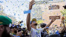Pemain Guard Golden State Warriors, Stephen Curry saat menggelar parade Warriors 2018 usai menjuarai NBA 2018 di pusat kota Oakland, California, Amerika Serikat, (12/6). (AP Photo/Marcio Jose Sanchez)