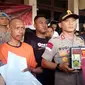 Kapolres Garut AKBP Budi Satria Wiguna menunjukan barang bukti berupa laptop yang digunakan tersangka Hamdani, dalam membuat dan menyebarkan surat edaran nabi palsu Sensen sebagai Presiden Republik Indonesia (Liputan6.com/Jayadi Supriadin)