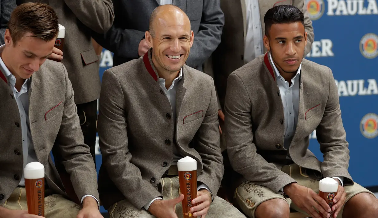 Pemain Beyern Christian Fruechtl, Arjen Robben dan Corentin Tolisso saat mengikuti sesi pemotretan perusahaan bir di Munich, Jerman, (13/9). (AP Photo/Matthias Schrader)