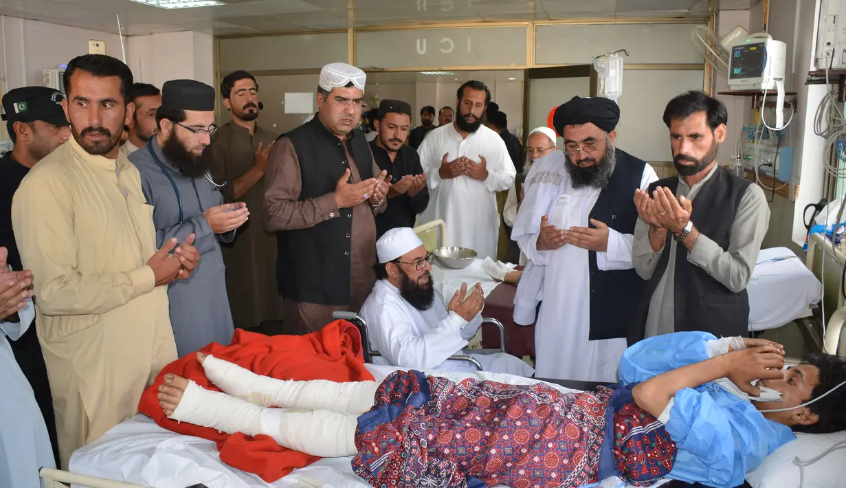 Wakil ketua Majelis Tinggi Parlemen Pakistan, Maulana Abdul Ghafoor Haideri (tengah) mendoakan seorang korban ledakan bom bunuh diri di sebuah rumah sakit pemerintah di Quetta, Selasa (16/5). (AFP FOTO / BANARAS KHAN)