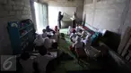 Murid SD mengikuti kegiatan belajar mengajar di Sekolah Terbuka, Kampung Manggar, Balikpapan, Kaltim, Kamis (29/10). Minimnya fasilitas, membuat kegiatan belajar terpaksa dilakukan di gudang bekas penyimpanan rumput laut. (Liputan6.com/Immanuel Antonius)