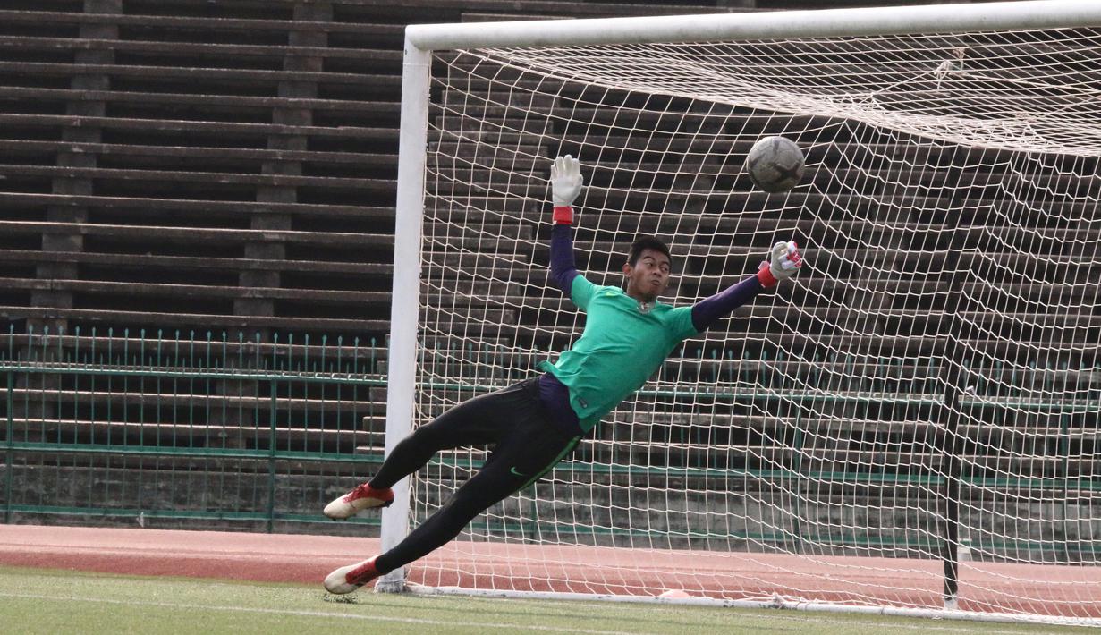 Kiper Timnas Indonesia U-22, Satria Tama, berusaha menghalau bola saat latihan jelang laga final Piala AFF U-22 2019 di Olympic Stadium, Phnom Penh, Kamboja, Senin (25/2/2019). Indonesia akan melawan Thailand. (Bola.com/Zulfirdaus Harahap)