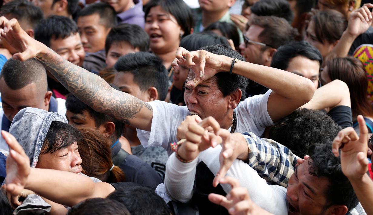 Seorang pria kesurupan meniru binatang buas selama Festival Tato Suci di kuil Wat Bang Phra, Nakhon Pathom, Thailand (16/3). Di festival ini, peserta mengalami kesurupan dengan gaya sesuai gambar tato yang mereka miliki. (Reuters/Athit Perawongmetha)