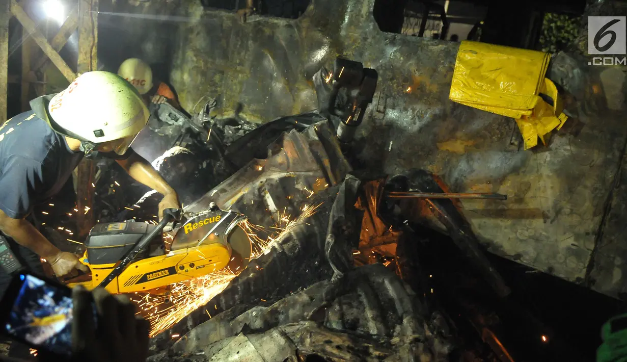 Petugas memotong puing yang menghimpit korban kecelakaan kereta api di perlintasan Kramat, Senen, Jakarta, Selasa (13/6). Petugas menemukan dua orang yang tewas terbakar. (Liputan6.com/Helmi Afandi)