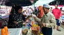 Beragam penganan dan kudapan dijajakan di sejumlah pasar di sekitar jalan-jalan utama kota Narathiwat yang menjadi pusat perburuan menu makanan untuk berbuka puasa bagi warga lokal. Tampak dalam foto, orang-orang membeli makanan untuk berbuka puasa pada hari pertama bulan suci Ramadan 1447 Hijriah di sebuah pasar di provinsi Narathiwat, Thailand selatan, pada Kamis 19 Februari 2026. (Madaree TOHLALA/AFP)