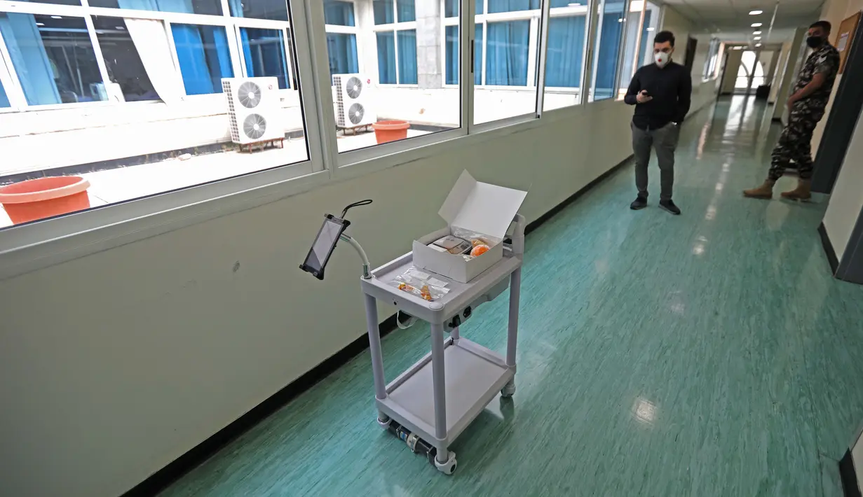 Perancang robot mengendalikan troli robot melalui ponsel di Rumah Sakit Universitas Rafic Hariri di Beirut, 6 Mei 2020. Universitas Lebanon meluncurkan troli robot yang dirancang mahasiswanya untuk membantu dokter dan perawat dalam mengurangi kontak dengan pasien COVID-19. (Xinhua/Bilal Jawich)