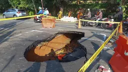 Pengendara melintas di sisi ruas jalan yang ditutup sebagian akibat amblas di Jalan Raya Lenteng Agung, Jakarta Selatan, Jumat (29/5/2026). (merdeka.com/Arie Basuki)
