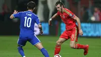 Pemain Wales, Gareth Bale (kanan), mendapat pengawalan pemain Bosnia-Herzegovina, Miralem Pjanic (kiri), pada laga Kualifikasi Piala Eropa 2016 Grup B di Stadion Bilino Polje, Zenica, Minggu (11/10/2015) dini hari WIB. (Reuters / Matthew Childs)