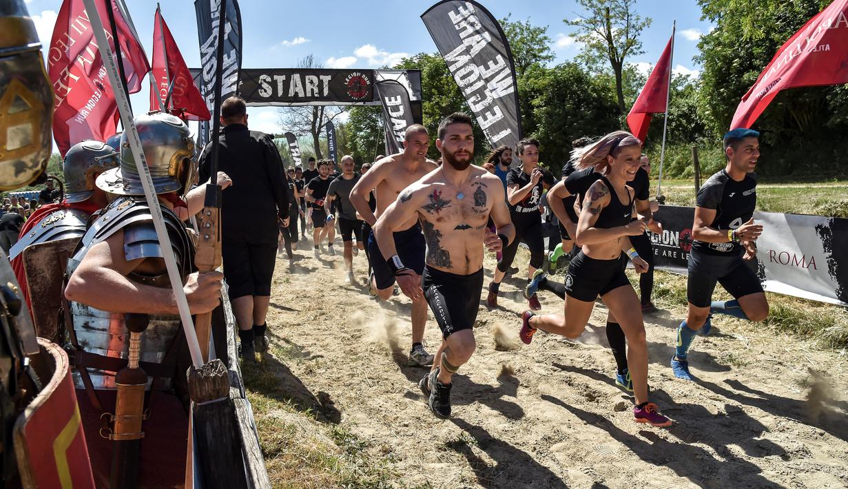 Peserta lomba memulai start "Legion Run" di Roma, Italia, Sabtu (13/4). Peserta harus melewati rintangan seperti dari lumpur, es dan kawat berduri dengan jarak tempuh 5 kilometer. (AFP PHOTO / Andreas SOLARO)