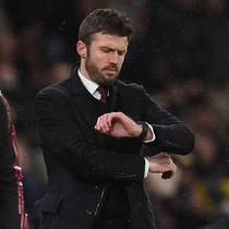 Hal itu disampaikan MU di laman resmi klub pada Rabu (14/1/2026) dini hari WIB. Tampak dalam foto, Michael Carrick saat masih menjadi pelatih sementara Manchester United melihat arlojinya selama pertandingan sepak bola Liga Premier Inggris melawan Arsenal di Old Trafford, Manchester, Inggris barat laut, pada 2 Desember 2021. (Oli SCARFF/AFP)