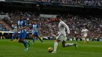 Penyerang Real Madrid, Cristiano Ronaldo berusaha melewati pemain Malaga, Luis Hernandez saat bertanding pada lanjutan La Liga Spanyol di stadion Santiago Bernabeu di Madrid, (25/11). Real Madrid menang 3-2 atas Malaga. (AP Photo / Francisco Seco)