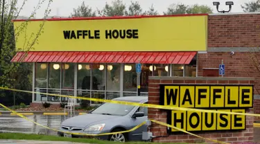 Garis polisi terpasang di lokasi penembakan yang terjadi di  area restoran Waffle House dekat Nashville, Tennessee, Minggu (23/4). Seorang pria telanjang hanya berjaket hijau menembak mati sedikitnya empat orang di kedai tersebut. (AP Photo/Mark Humphrey)