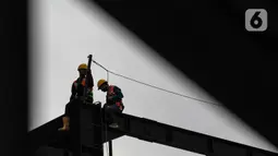 Pekerja konstruksi beraktivitas di proyek pembangunan gedung di Jakarta, Selasa (16/3/2021). Deputi Direktur Bidang Ketenagakerjaan Operasional Program BPJS Ketenagakerjaan Yasaruddin menuturkan tren kecelakaan kerja menurun sejak 2019, dari sebelumnya 173.415 pada 2018. (merdeka.com/Imam Buhori)