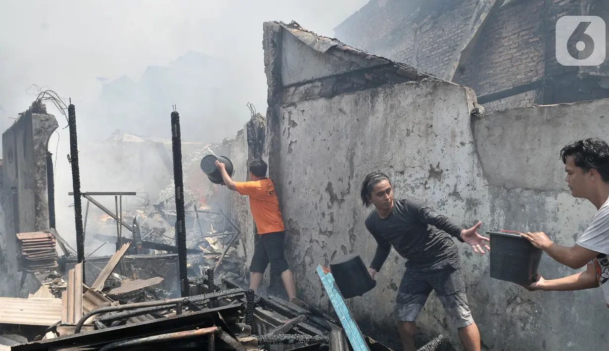 Warga bergotong royong memadamkan api yang membakar permukiman di Jalan Kebon Jeruk 13, Taman Sari, Jakarta Barat, Minggu (6/10/2019). Kebakaran diduga akibat anak bermain korek api. (merdeka.com/Iqbal Nugroho)