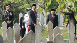 Hari Pahlawan: Presiden Joko Widodo bersama Wapres Ma'ruf Amin bersiap tabur bunga usai upacara peringatan Hari Pahlawan Nasional di TMP Utama Kalibata, Jakarta Selatan, Minggu (10/11/2019). Tabur bunga dilaksanakan sebagai bentuk penghormatan terhadap jasa pahlawan. (Liputan6.com/Herman Zakharia)