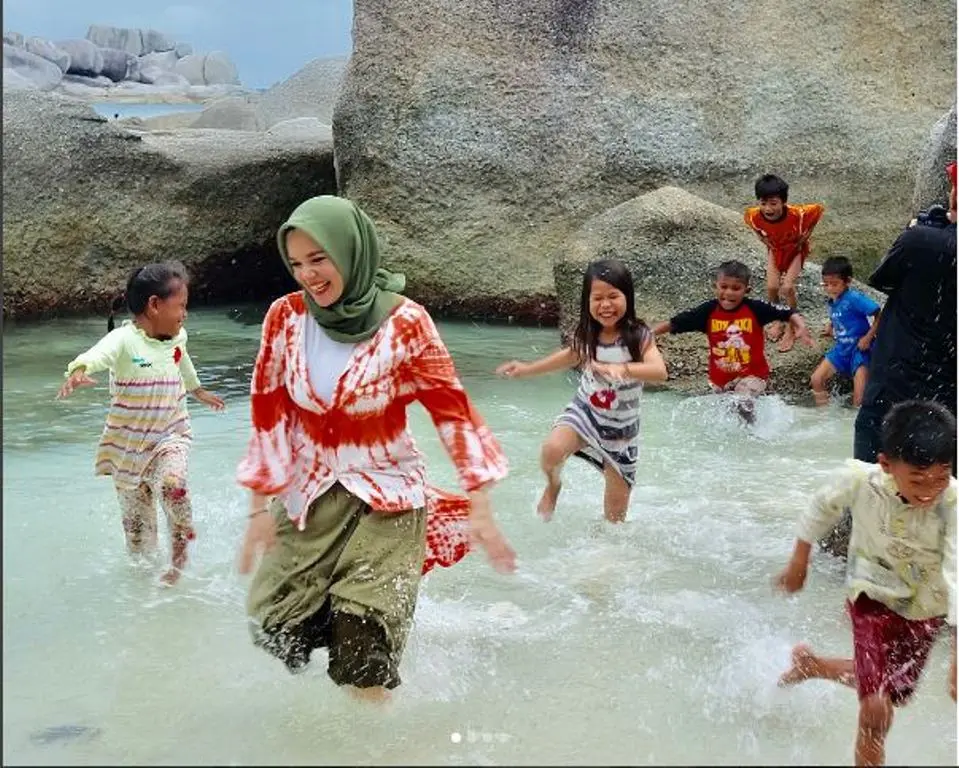 Dewi Sandra ceria bermain dengan anak-anak di pantai Laskar Pelangi (Foto:Instagram)