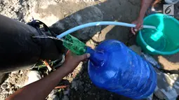 Warga memanfaatkan air bersih dari kebocoran pipa PDAM di Jalan Lagarutu, Palu Sulawesi Tengah, Rabu (3/10). Pipa hitam berukuran besar keluar dari dalam tanah pasca gempa tsunami. (Liputan6.com/Fery Pradolo)