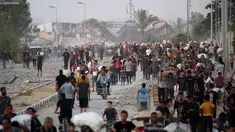 Warga Palestina berjalan di sepanjang jalan al-Rashid, Jabalia barat pada 23 Juli 2025, setelah menerima bantuan kemanusiaan dari titik distribusi bantuan di Jalur Gaza utara. (Eyad BABA/AFP)