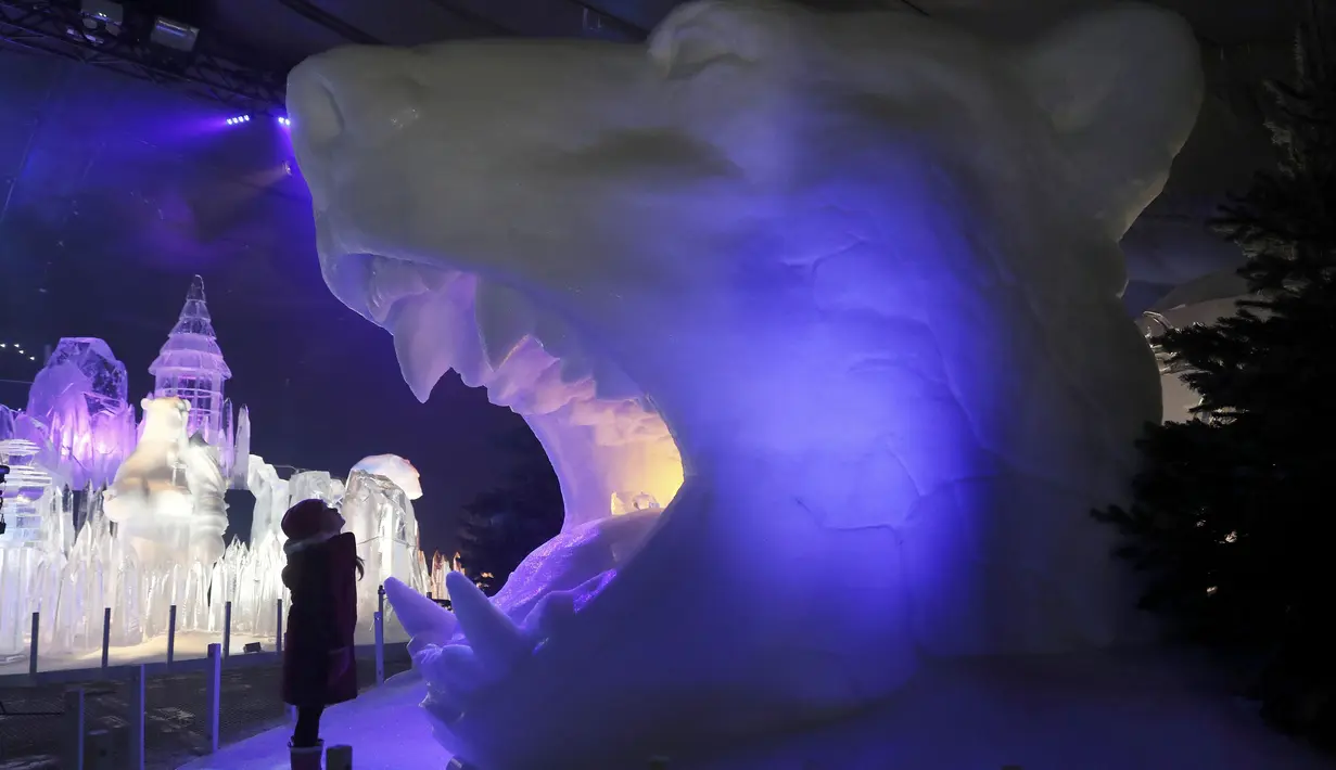 Seorang anak melihat patung es berbentuk kepala macan di kerajaan es Hyde Park Winter Wonderlands Magical Ice, London, Kamis (17/11). Hyde Park Winter Wonderlands Magical Ice dibuka untuk memeriahkan musim dingin di Inggris. (Reuters/stefan wermuth)
