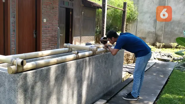 Salah Seorang Pengunjung Membasuh Mukanya Dengan Air Sumur Sritanjung Yang Konon Dipercaya Air Sumur Sritanjung Membuat Awet Muda . (Hermawan Arifianto/Liputan6.com)