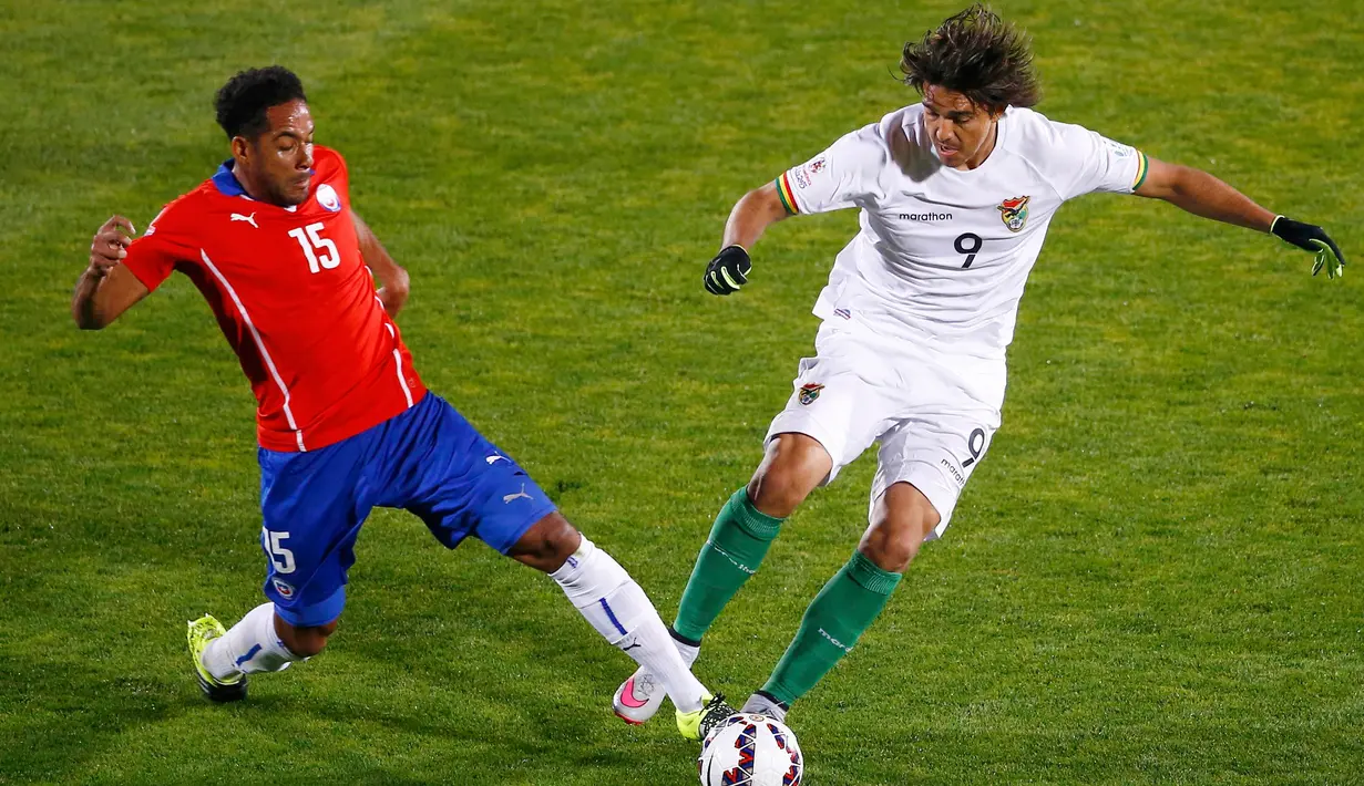 Penyerang Bolivia, Marcelo Martins (kanan) berusaha melewati bek Chile, Jean Beausejour saat pertandingan Copa Amerika 2015 di Estadio Nacional, Santiago, Chile, (20/6/2015). Chile menang telak 5-0 atas Bolivia. (REUTERS/Ricardo Moraes)