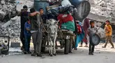 Penduduk Palestina mengangkut barang-barang mereka dengan kereta yang ditarik keledai saat mereka mengungsi dari kawasan Abu Iskandar di bagian utara Kota Gaza pada 22 Agustus 2025. (Bashar TALEB/AFP)
