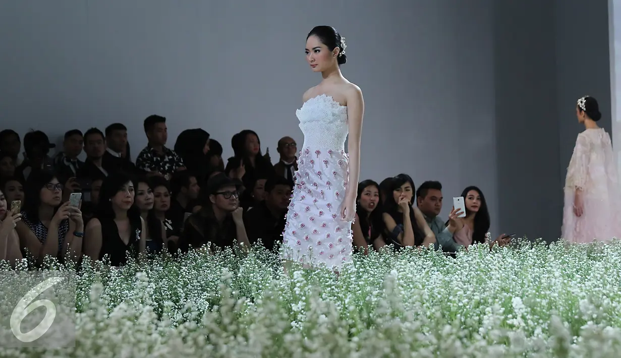 Model membawakan busana rancangan Hian Tje di acara IPMI Trend show 2016, Di Senayan City, Jakarta, Selasa  (1/12). Perancang Hian Tje  menghadirkan busana-busana feminin dan cantik berwarna pink. (Liputan6.com/Herman Zakharia)