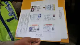 Petugas menunjukan sejumlah identitas milik Rocky Herdarmel saat gelar barang bukti di Mapolda Metro Jaya, Jakarta, Selasa (2/6/2015). Rocky diringkus polisi saat menerobos busway di Jalan Panjang, Kebonjeruk, Jakarta Barat. (Liputan6.com/Johan Tallo)