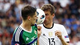 Pemain Jerman, Thomas Muller, berebut bola dengan pemain Irlandia Utara, Craig Cathcar, pada laga Grup C Piala Eropa 2016 di Parc des Princes, Paris, Selasa (21/6/2016). (AFP/Lionel Bonaventre)