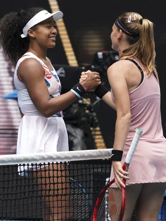Petenis Jepang Naomi Osaka bersalaman dengan Marie Bouzkova dari Republik Ceko usai pertandingan putaran pertama tenis Australia Terbuka di Melbourne, Australia, Senin (20/1/2020). Pertandingan ini merupakan pertemuan pertama Osaka dengan Bouzkova. (AP Photo/Lee Jin-man)