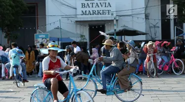 Warga naik sepeda hias di pelataran Museum Fatahillah, Jakarta, Selasa (19/6). Kemudahan transportasi dan biaya yang murah menjadikan kawasan ini sebagai lokasi favorit warga untuk menghabiskan waktu libur. (Liputan6.com/Helmi Fithriansyah)